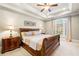 Spacious bedroom featuring a tray ceiling, large window, and a sleek ceiling fan at 841 Camden Park Ne Ct, Atlanta, GA 30342
