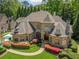 Elegant home with stone facade, lush landscaping, and a multi-sport court adjacent to the driveway at 841 Camden Park Ne Ct, Atlanta, GA 30342