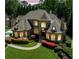 Stunning stone home boasts a lush lawn, manicured landscaping, and elegant architectural details at 841 Camden Park Ne Ct, Atlanta, GA 30342