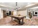 Open game room with pool table, staircase and hardwood floors at 841 Camden Park Ne Ct, Atlanta, GA 30342