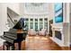 Bright living room showcases a fireplace, a grand piano, and large windows with views of the yard at 841 Camden Park Ne Ct, Atlanta, GA 30342