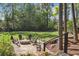 Lush backyard features a stone patio with seating and a fire pit, creating an idyllic setting for outdoor gatherings at 900 Crossfire Nw Rdg, Marietta, GA 30064