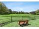 Serene community green space featuring a wooden fence, seating, and expansive views of the lawn and trees at 900 Crossfire Nw Rdg, Marietta, GA 30064