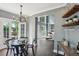 Dining room features a modern chandelier, glass table, and access to outdoor patio at 900 Crossfire Nw Rdg, Marietta, GA 30064