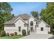 A beautifully landscaped home featuring a white exterior with a well-manicured lawn and mature trees at 900 Crossfire Nw Rdg, Marietta, GA 30064