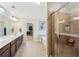 Bright primary bathroom with double vanity, glass enclosed shower, and a walk-in closet at 2315 Saddle Brook Trce, Cumming, GA 30040