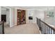 Upstairs hallway with large bookshelf, railing, and views to other living areas at 2315 Saddle Brook Trce, Cumming, GA 30040