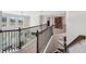 Upstairs hallway overlooking the living area, enhanced by rod iron railings and plush carpet at 2315 Saddle Brook Trce, Cumming, GA 30040