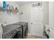 The laundry room features modern washer and dryer units and a door to storage at 2315 Saddle Brook Trce, Cumming, GA 30040