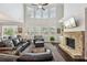 Spacious living room features soaring windows, a stone fireplace, and a comfortable leather sofa at 2315 Saddle Brook Trce, Cumming, GA 30040