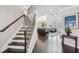 Staircase with wooden steps and wrought iron railing leading to a living room with large windows at 2315 Saddle Brook Trce, Cumming, GA 30040
