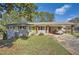 Charming exterior featuring a light grey brick facade, lime green front door, and covered carport at 2376 Falls River Dr, Lithia Springs, GA 30122
