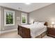 Cozy bedroom with a wooden sleigh bed, two windows, and neutral paint at 286 Norwood Ne Ave, Atlanta, GA 30317