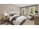 Comfortable bedroom featuring neutral decor, a plush bed, an armchair, and two windows at 286 Norwood Ne Ave, Atlanta, GA 30317