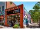 Boutique featuring a colorful mural, brick facade, large storefront windows, and charming street-side plants at 286 Norwood Ne Ave, Atlanta, GA 30317