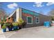 Dancing Goats Coffee Bar features a modern gray building with bright blue signage and outdoor seating with orange umbrellas at 286 Norwood Ne Ave, Atlanta, GA 30317