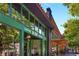 Inviting coffee and bagel shop with a vibrant green storefront, large windows, and sidewalk seating at 286 Norwood Ne Ave, Atlanta, GA 30317