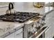 Close up of kitchen stove top featuring granite countertops and stainless steel appliances at 286 Norwood Ne Ave, Atlanta, GA 30317