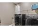 Laundry room showcasing a washer, dryer, white cabinet, and wire shelving at 286 Norwood Ne Ave, Atlanta, GA 30317