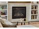 Cozy living room featuring a stacked stone fireplace and built-in bookshelves at 286 Norwood Ne Ave, Atlanta, GA 30317