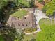 A stunning aerial view of the home, highlighting the large lot, putting green, and mature trees surrounding the estate at 299 Saint Marys Nw Ln, Marietta, GA 30064