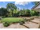 Beautiful backyard featuring green grass, professional landscaping, and a stone patio area at 299 Saint Marys Nw Ln, Marietta, GA 30064
