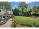 Expansive backyard with lush lawn, stone patio, outdoor seating, and manicured landscaping at 299 Saint Marys Nw Ln, Marietta, GA 30064