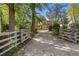 Inviting driveway entrance framed by mature trees and a charming gate, leading to a beautiful home in a serene setting at 299 Saint Marys Nw Ln, Marietta, GA 30064