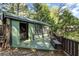 Charming green outbuilding with an open deck and dark trim nestled among lush trees at 299 Saint Marys Nw Ln, Marietta, GA 30064