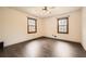 Neutral bedroom with hardwood flooring, two windows, and ceiling fan at 1766 Scholar Dr, Lawrenceville, GA 30044