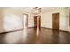 Large empty bedroom featuring dark laminate flooring and multiple doors at 1766 Scholar Dr, Lawrenceville, GA 30044