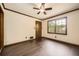 Empty bedroom with a ceiling fan, dark laminate flooring, and a single window at 1766 Scholar Dr, Lawrenceville, GA 30044
