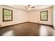 An empty bedroom featuring dark laminate flooring and two windows at 1766 Scholar Dr, Lawrenceville, GA 30044