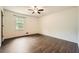 Bedroom with hardwood flooring, neutral walls, ceiling fan, and bright window at 1766 Scholar Dr, Lawrenceville, GA 30044