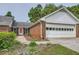 Attractive brick home with an attached garage and manicured landscaping at 1766 Scholar Dr, Lawrenceville, GA 30044