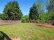 Well-maintained backyard with lush green grass, landscaping, and a charming wood fence at 2402 Jasmine Glen Dr, Buford, GA 30519