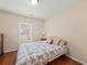 Bedroom featuring hardwood floors, ceiling light, large window and side table at 2402 Jasmine Glen Dr, Buford, GA 30519