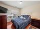 Well lit bedroom with hardwood floors, large window, flatscreen TV and ceiling light at 2402 Jasmine Glen Dr, Buford, GA 30519