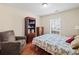 Comfortable bedroom with hardwood floors, cozy armchair, large window and ceiling light at 2402 Jasmine Glen Dr, Buford, GA 30519