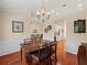 Elegant dining space with hardwood floors, wainscoting, chandelier, and open flow to living spaces at 2402 Jasmine Glen Dr, Buford, GA 30519
