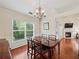 Well-lit dining room featuring hardwood floors, chandelier, wainscoting, and a window overlooking a green landscape at 2402 Jasmine Glen Dr, Buford, GA 30519