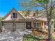 Charming home featuring a stone facade, attached two-car garage, and a well-manicured front yard with an American flag at 2402 Jasmine Glen Dr, Buford, GA 30519