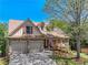 Charming home featuring a stone facade, attached two-car garage, and a well-manicured front yard with an American flag at 2402 Jasmine Glen Dr, Buford, GA 30519
