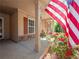 Inviting front porch with stone accents, decorative shutters, blooming roses, and an American flag on display at 2402 Jasmine Glen Dr, Buford, GA 30519