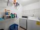 Practical laundry room features ample shelving, washer, dryer and tile floors at 2402 Jasmine Glen Dr, Buford, GA 30519