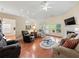 Bright living room features hardwood floors, fireplace, ceiling fan, and large windows overlooking the backyard at 2402 Jasmine Glen Dr, Buford, GA 30519