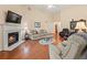 Spacious living room with hardwood floors, a cozy fireplace, and comfortable seating, perfect for relaxation at 2402 Jasmine Glen Dr, Buford, GA 30519