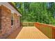 This is a wooden deck adjacent to a brick building; it overlooks a yard with many trees at 2645 Davenport Rd, Duluth, GA 30096
