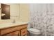 Bathroom featuring a wood vanity, patterned shower curtain, and standard toilet at 2645 Davenport Rd, Duluth, GA 30096