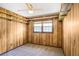 Carpeted bedroom with wood paneled walls, shelving and a window providing natural light at 2645 Davenport Rd, Duluth, GA 30096